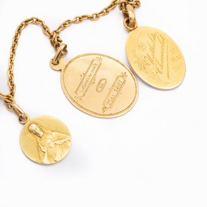 null Chaîne en or jaune 18 K (750) ornée de trois médailles religieuses, gravées....