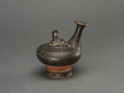 null GUTTUS in black glazed terracotta decorated with a mask of Minerva

Greece,...