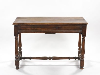 null Table en noyer mouluré et sculpté, les pieds tournés en balustre, reliés par...