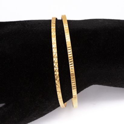 null Deux bracelets joncs rigides ciselés en or jaune (750) 18K. 

Poids : 11,70...