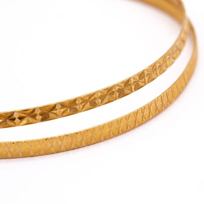 null Deux bracelets joncs rigides ciselés en or jaune (750) 18K. 

Poids : 11,70...