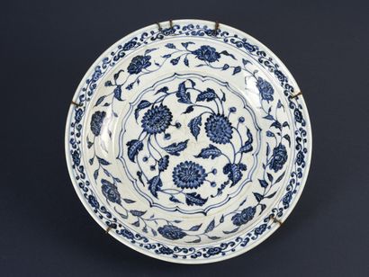  CHINE : Grand plat circulaire en porcelaine décoré en bleu sous couverte de pivoines...