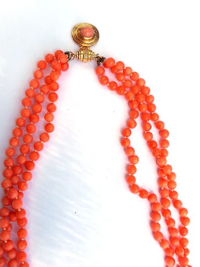 null Twisted necklace with three rows of coral pearls centered on a yellow gold clasp,...