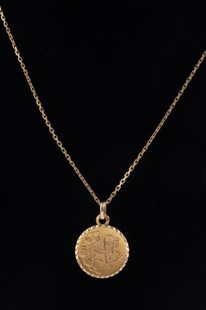 null Circular medal in yellow gold, engraved with initailes and a chain in yellow...