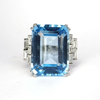 null Art Deco style ring in 18K white gold set with a 13.95 carat emerald cut blue...