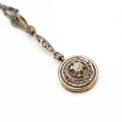 null Chain and pendant in platinum and 18K gold. 

Circular pendant set with a diamond...