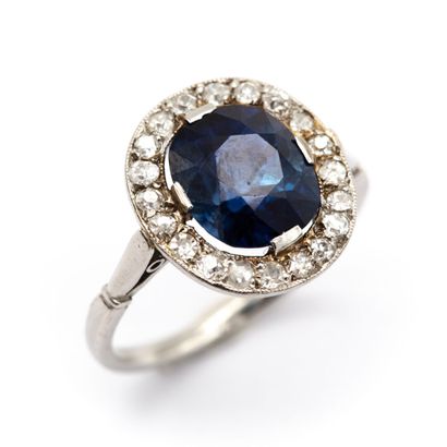 null Oval platinum ring with a cushion sapphire, surrounded by pearl-set old-cut...