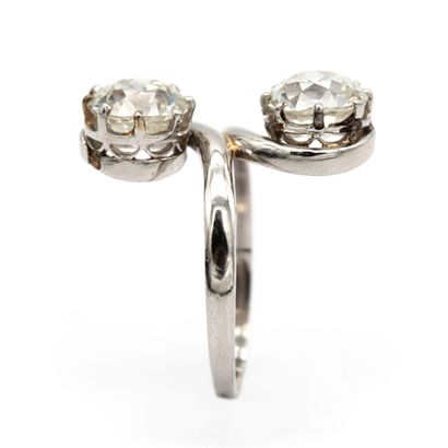 null A platinum "you and me" ring set with two old-cut diamonds, each weighing approximately...