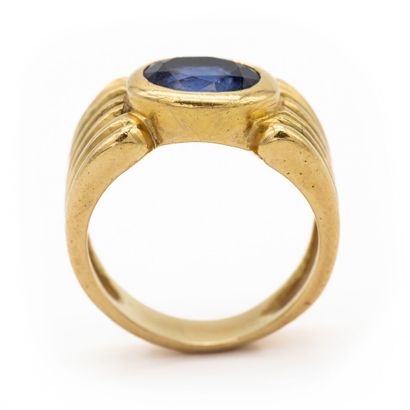 null Important 18K (750) yellow gold band ring, with an oval sapphire set in a closed...