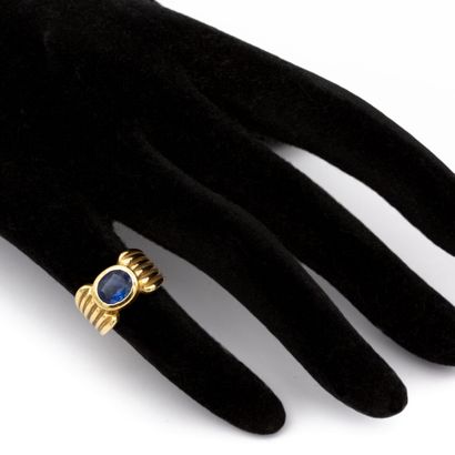 null Important 18K (750) yellow gold band ring, with an oval sapphire set in a closed...