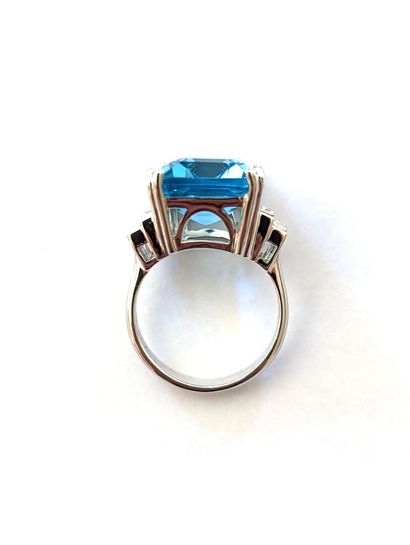 null Art Deco style ring in 18K white gold set with a 13.95 carat emerald cut blue...