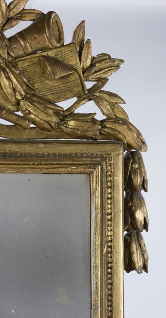 null Miroir à fronton en bois sculpté et doré à décor d'un trophée d'instrument de...