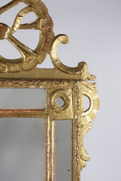 null Miroir à fronton en bois doré et sculpté d'un trophée d'instruments de musique...