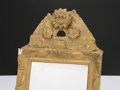 null A giltwood and carved mirror with a heliotrope flower 
18th century.
42 x 27...