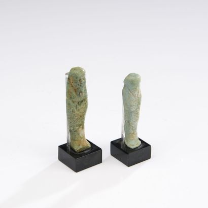 null Lot of two oushebtis anépigraphes carrying the beard postiche.
Green earthenware....