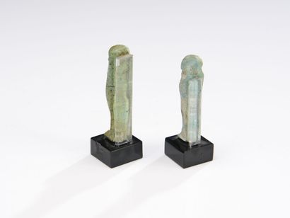 null Lot of two oushebtis anépigraphes carrying the beard postiche.
Green earthenware....