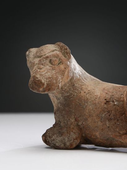 null Figurine of a lion lying down, head turned to the left.
Ochre terracotta. Missing...