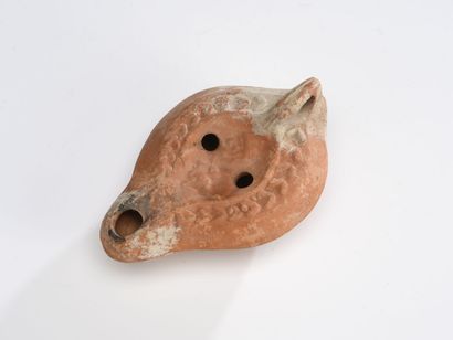 null Oil lamp with channel spout decorated with a medallion showing a male bust holding...