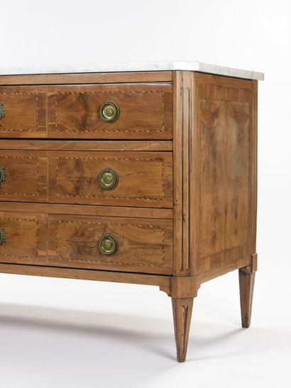 null A rectangular chest of drawers in wood veneer, it opens with three drawers in...