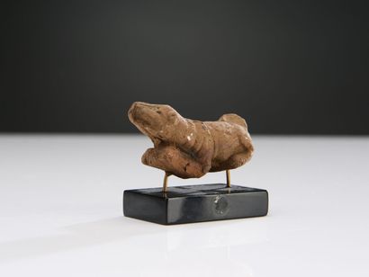 null Small statuette of a dog lying down, head raised, and wearing a harness.
Brown-red...