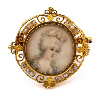 null Brooch in 18 K (750) yellow gold. Filigree setting enhanced with half pearls...