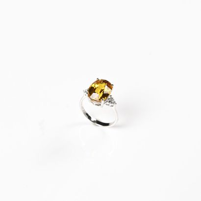 null 18K (750) white gold ring set with a large oval-cut, treated yellow sapphire...