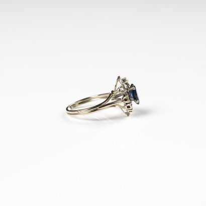 null 18K (750) white gold ring set with a navette-cut sapphire in a double twist...