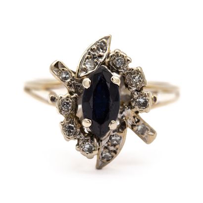 null 18K (750) white gold ring set with a navette-cut sapphire in a double twist...