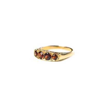 null Bague jarretière en or jaune 18 K (750), suite de cinq grenats. Poids 2,8 g...