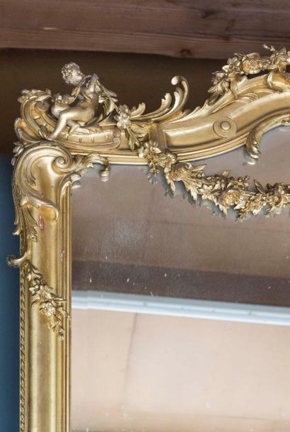 null Paire d'importants miroirs en stuc doré, à décor de guirlandes fleuries et fronton...