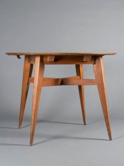 Roger LANDAULT (1919-1983) Table haute et ronde en placage de chêne foncé s'ouvrant...