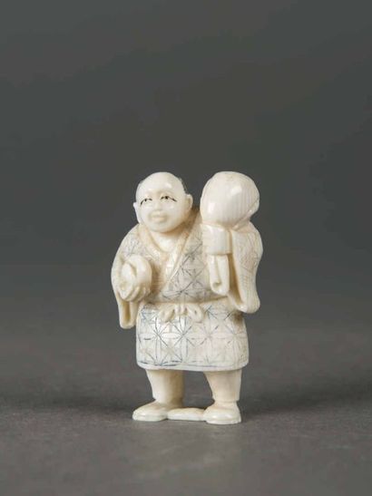 null JAPON Netsuké en ivoire sculpté et rehaussé de polychromie. Homme portant un...