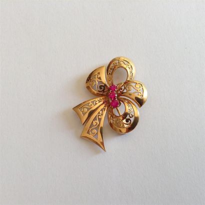 null Broche en or jaune (750) 18K figurant un noeud. Le lien serti de trois pierres...