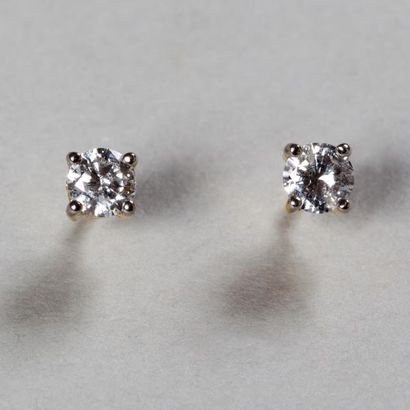 null Paire de puces d'oreilles en or blanc griffées de diamants. Poids des diamants...