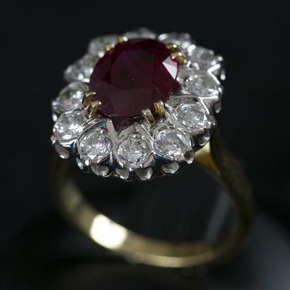 null Bague en or de deux tons griffée d'un rubis ovale, entouré de douze diamants....