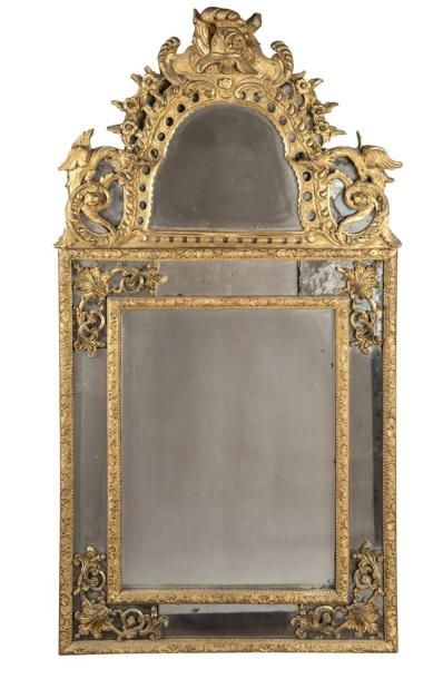 null Un miroir en bois doré à bandeau, décor de feuillage, casque et chimère, 
18ème...