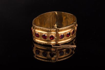 null Bracelet jonc articulé en or jaune (750) 18K, au centre une suite de grenats...