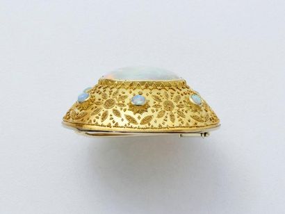 null Broche en or 750 millièmes, de forme ovale, centrée d'un impotant cabochon d'opale...