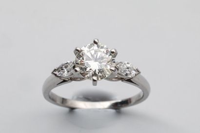 null Platinum ring set with one modern cut diamond of about 1 carat and two shuttle...