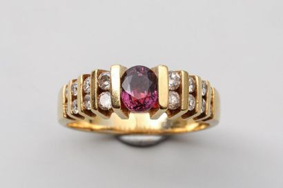 null Ring in 18k yellow gold with an oval cut ruby surrounded by a double row of...