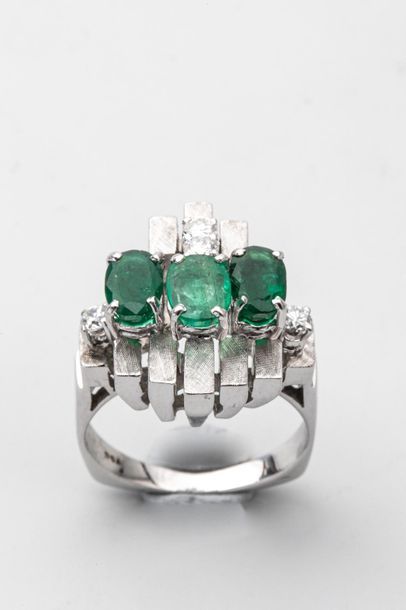 null Design ring in amati white gold decorated with three oval-cut emeralds and four...