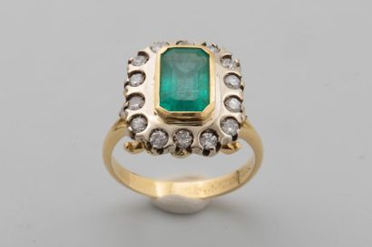 null Pompadour ring in 18k yellow gold centered with an emerald in a circle of small...