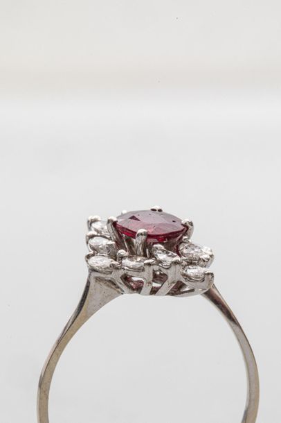 null Bague marquise en or gris 18k griffée d'un rubis ovale facetté entouré de diamants...