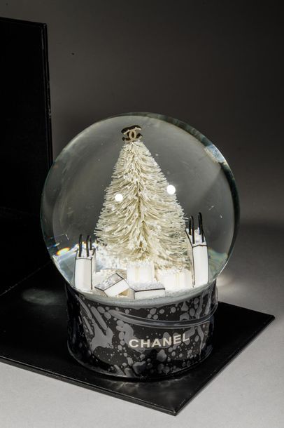 null CHANEL.Boule à neige à décor de sapin de Noël au pied duquel se trouvent de...