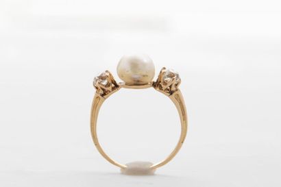 null Bague en or jaune 18k sertie d'une perle blanche baroque entre deux diamants...