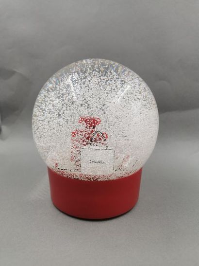 null CHANEL - Large motorized snowball featuring the Bottle N°5 in red, at its foot...