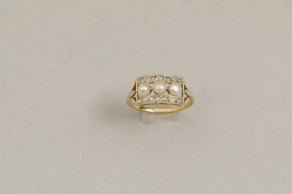 null Bague en or jaune 18k surmontée de trois petites perles entourées de deux lignes...