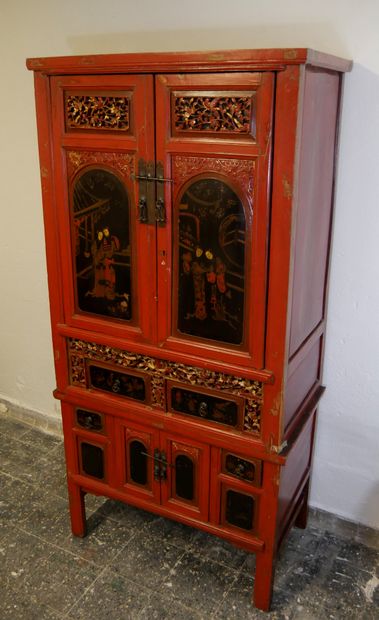 null 
Cabinet en bois laqué rouge ouvrant à deux vantaux en partie haute à décor...