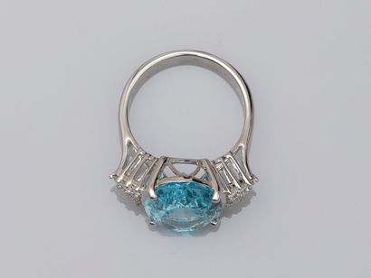 null 18k white gold ring surmounted by an oval blue topaz of about 9cts accosted...