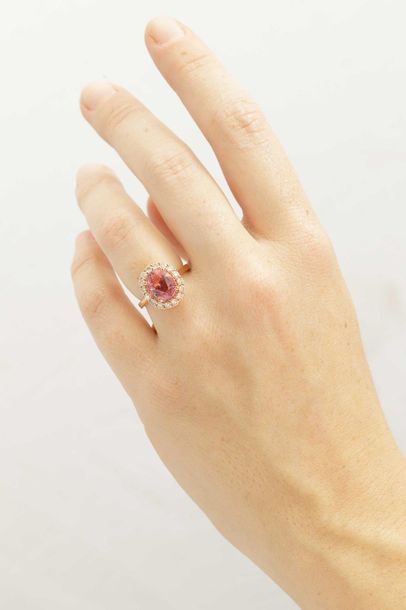 null 18k rose gold ring set with an oval pink tourmaline of about 3.50cts encircled...